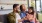 a family laughing and spending time together on a gray and green sofa