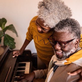 The essence of exceptional living a couple laughing and playing the piano
