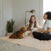 two girls on a bed with a dog